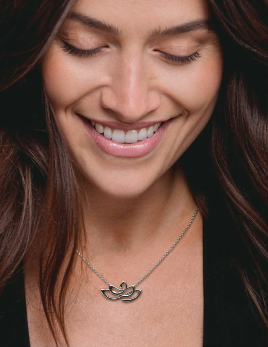 Lotus necklace silver charm on smiling woman model.