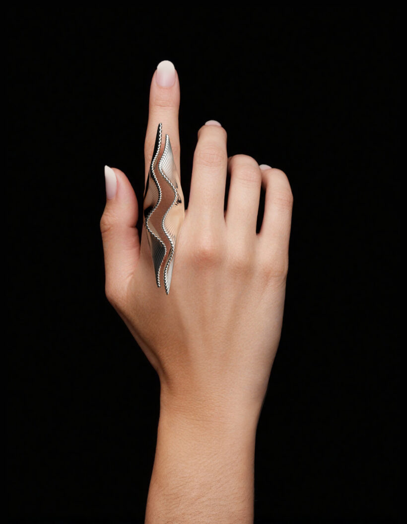 Hand wearing a large Ginkgo leaf silver ring with fan-shaped leaves.