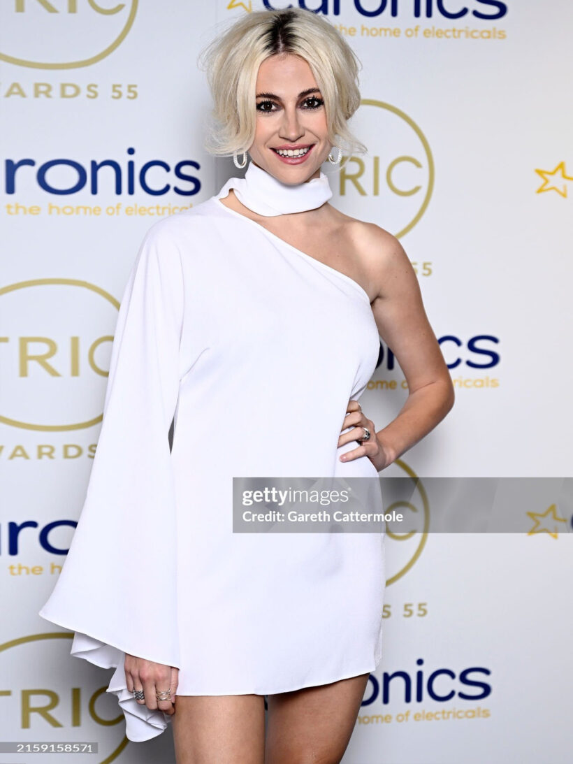 Pixie Pixie Lott posing on the red carpet, wearing a white one-shoulder dress and the Floa Design Wave Ring at the TRIC Awards 2024 in LondonLott wearing the sterling silver Wave Ring by Floa Design Jewellery at the TRIC Awards 2024 in London