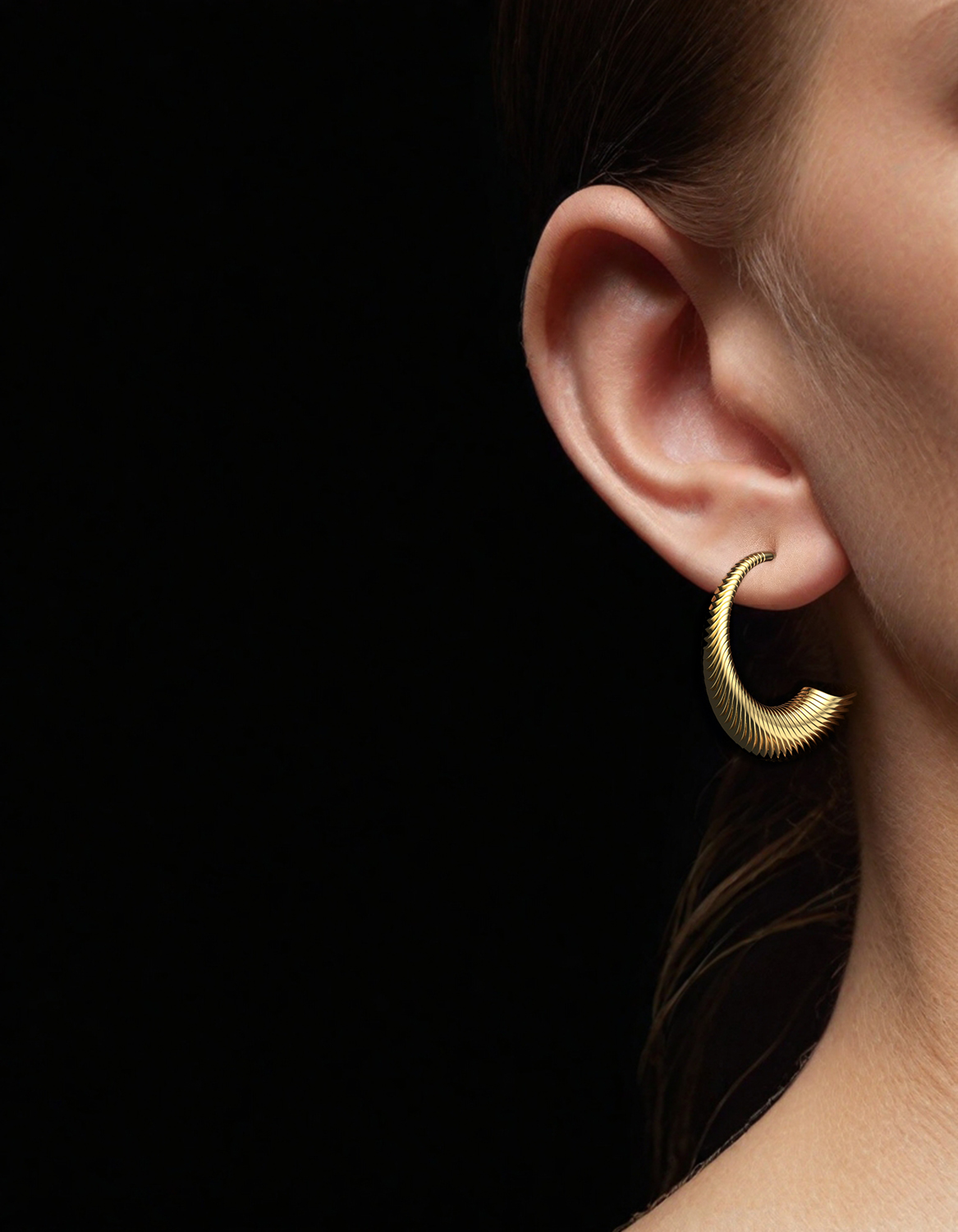 Designer hoop earrings in gold on womens ear by Floa Design Designer hoop earrings in gold on womens ear by Floa Design