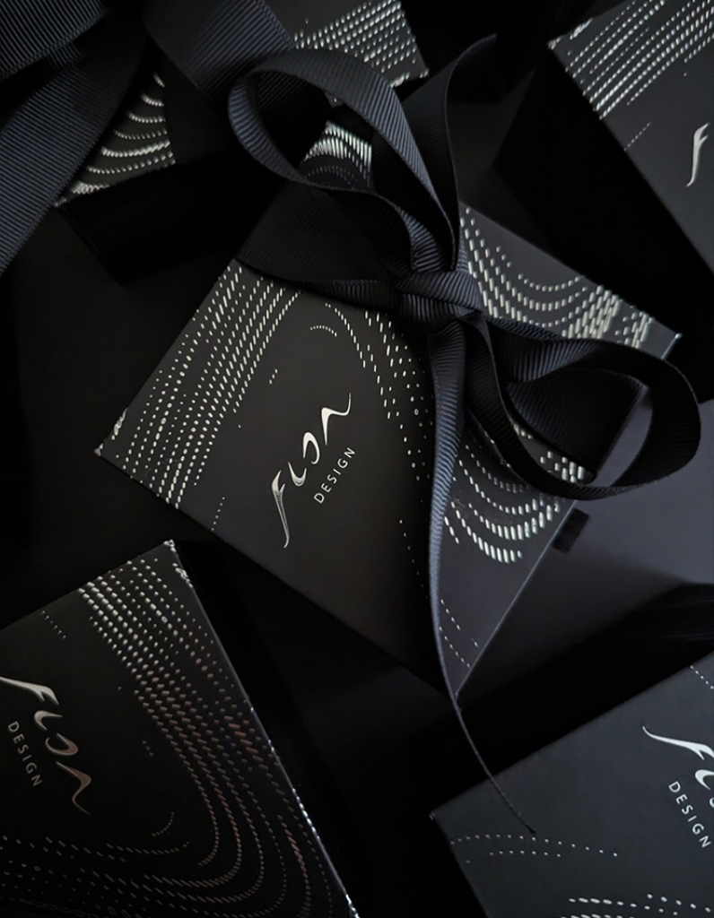 Luxury contemporary jewellery gift packaging boxes in black featuring meticulous parametric pattern in silver and black ribbon by Floa Design