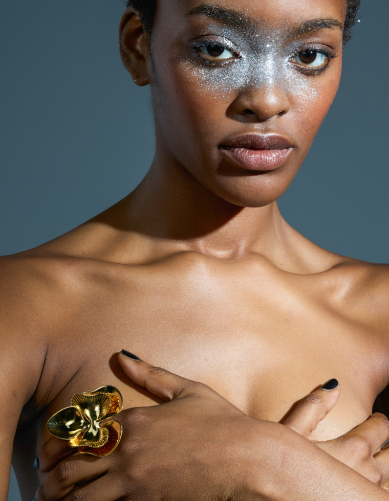 Model wearing a modern gold statement ring featuring an orchid flower blossom design by Floa Design