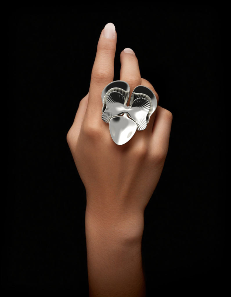Chunky silver statement ring featuring contemporary orchid flower design on woman's hand by Floa Design